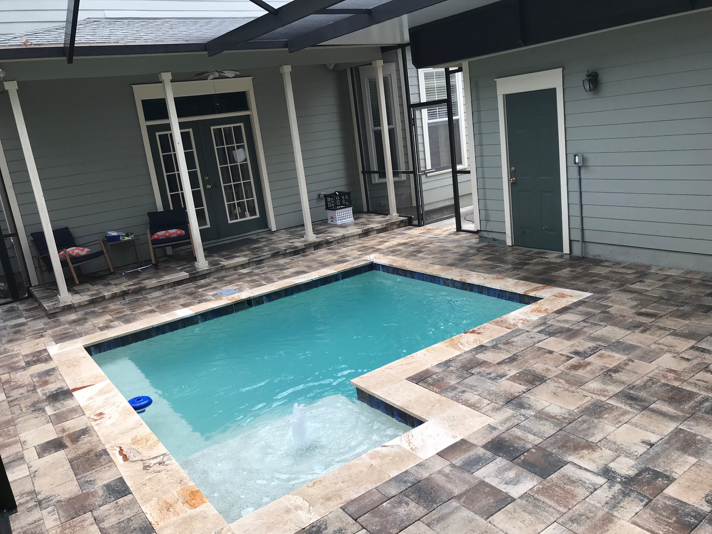 Paver and travertine pool deck and coping